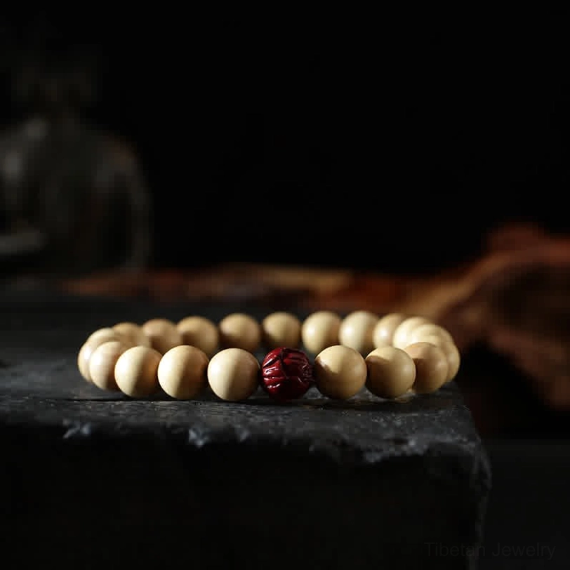 Cinnabar and peach wood bracelet combination - top-down still life showing red cinnabar bead with silver accents