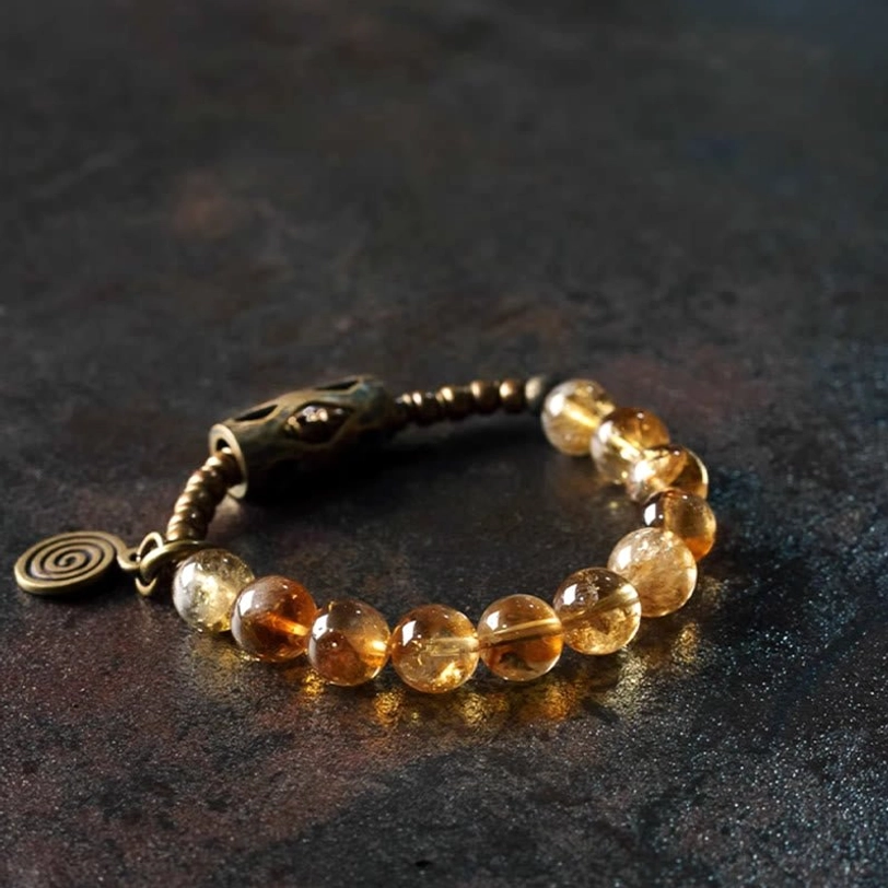 Close-up view of citrine beaded bracelet highlighting curved metal chain links and stone texture