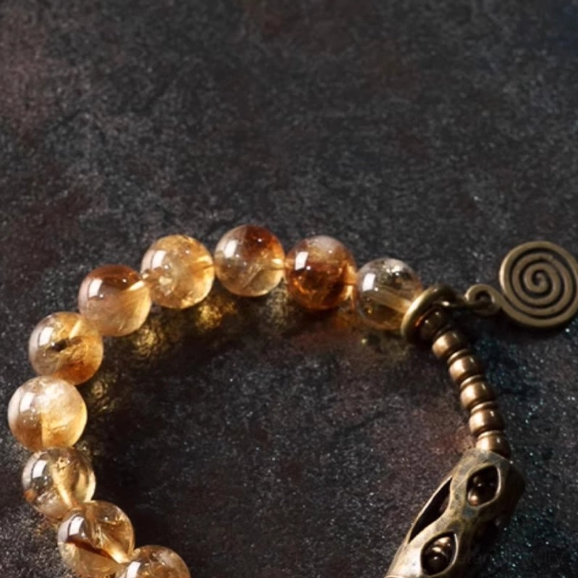 Extreme close-up of citrine beaded bracelet showcasing crystal transparency and vintage metal clasp detail