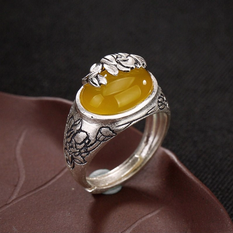 Vintage copper citrine lotus ring with adjustable open band showing carved silver mount and oval citrine stone, front top view on lotus tray