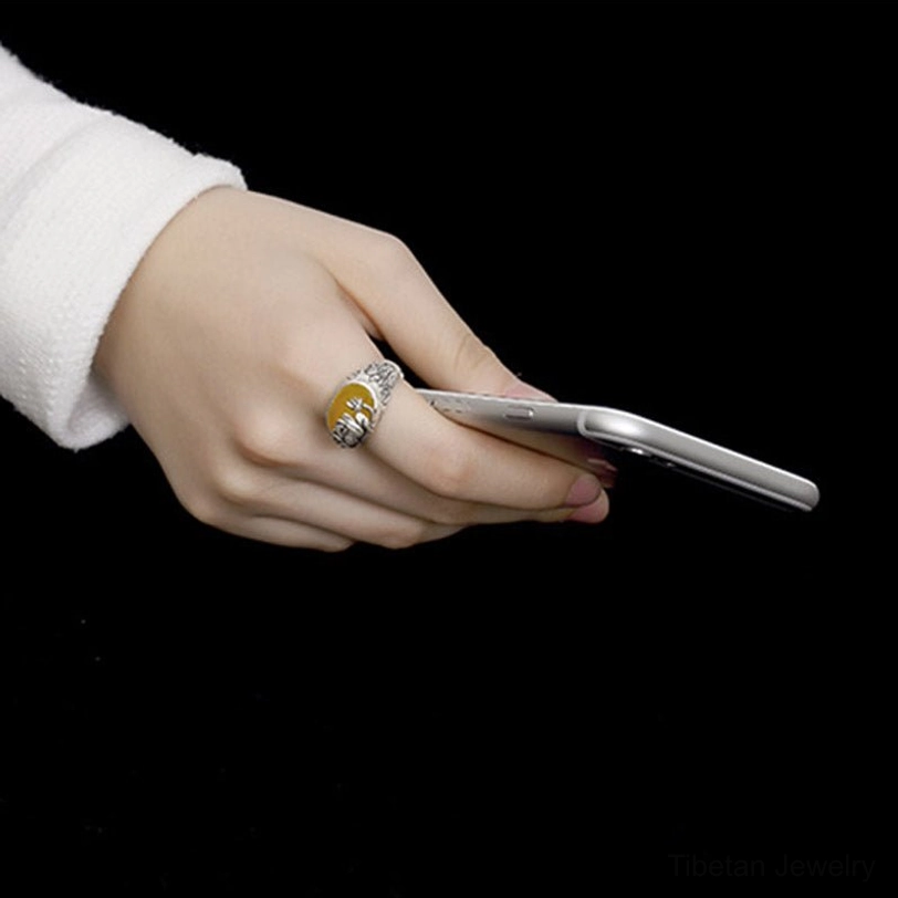 Citrine lotus blessing ring worn on hand holding mobile phone, side view showing detailed copper band and gemstone setting