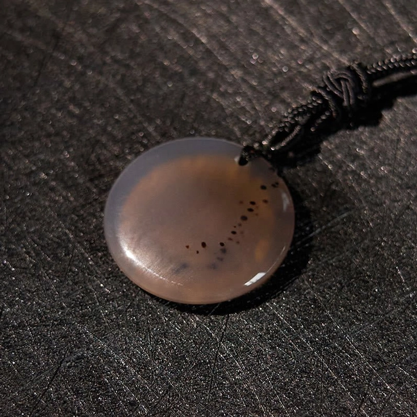 Clear quartz crystal pendant showing internal clarity and light reflection