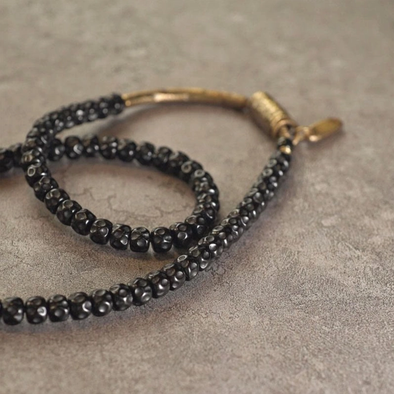 Double wrap handmade coconut shell bracelet with small black round beads and antiqued brass clasp