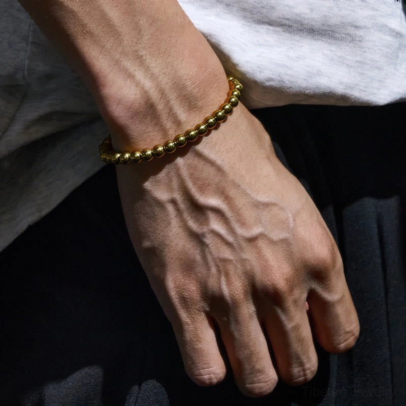 Tibetan brass bead bracelet worn on wrist with casual clothing lifestyle photo