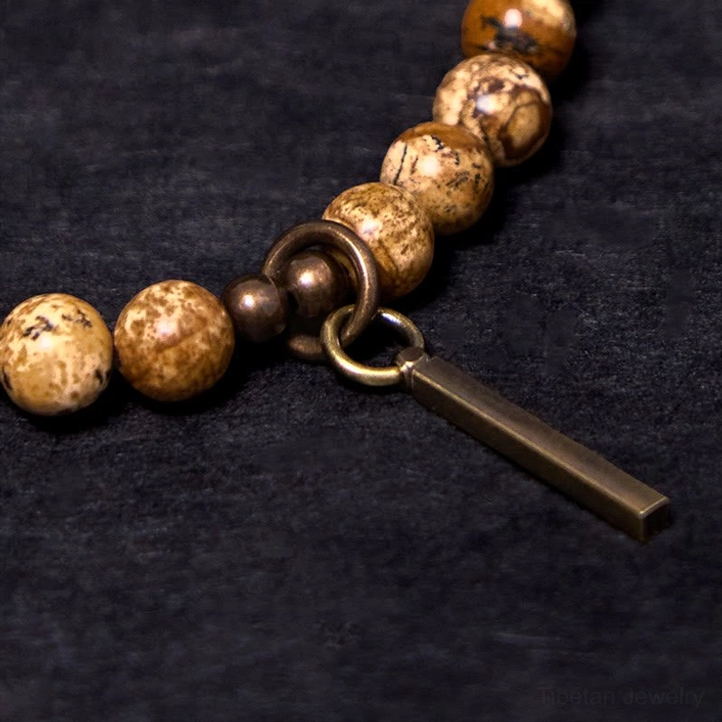 Macro shot of copper spring clasp and metal bar pendant, intricate bracelet hardware detail