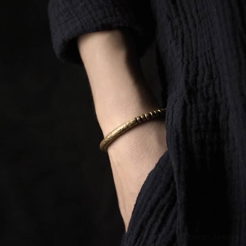 Copper brass beaded bracelet lifestyle wear on wrist with linen clothing, demonstrating slim minimalist fit for daily wear