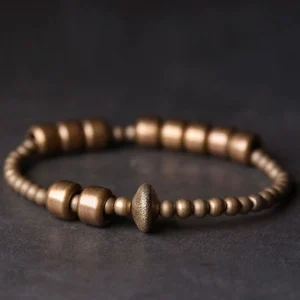 Close-up side view of textured copper bracelet showing premium 8mm beads with central rondelle accent on dark tabletop