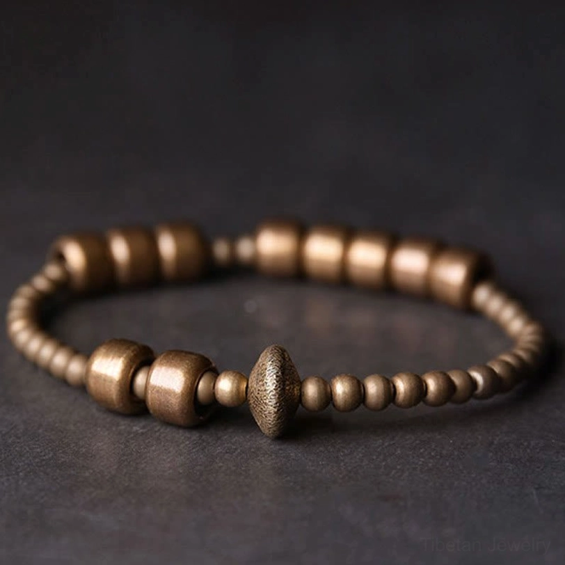 Close-up side view of textured copper bracelet showing premium 8mm beads with central rondelle accent on dark tabletop