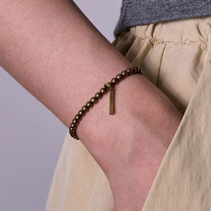 Healing bracelet worn on back of hand showing snug fit and antique bronze finish