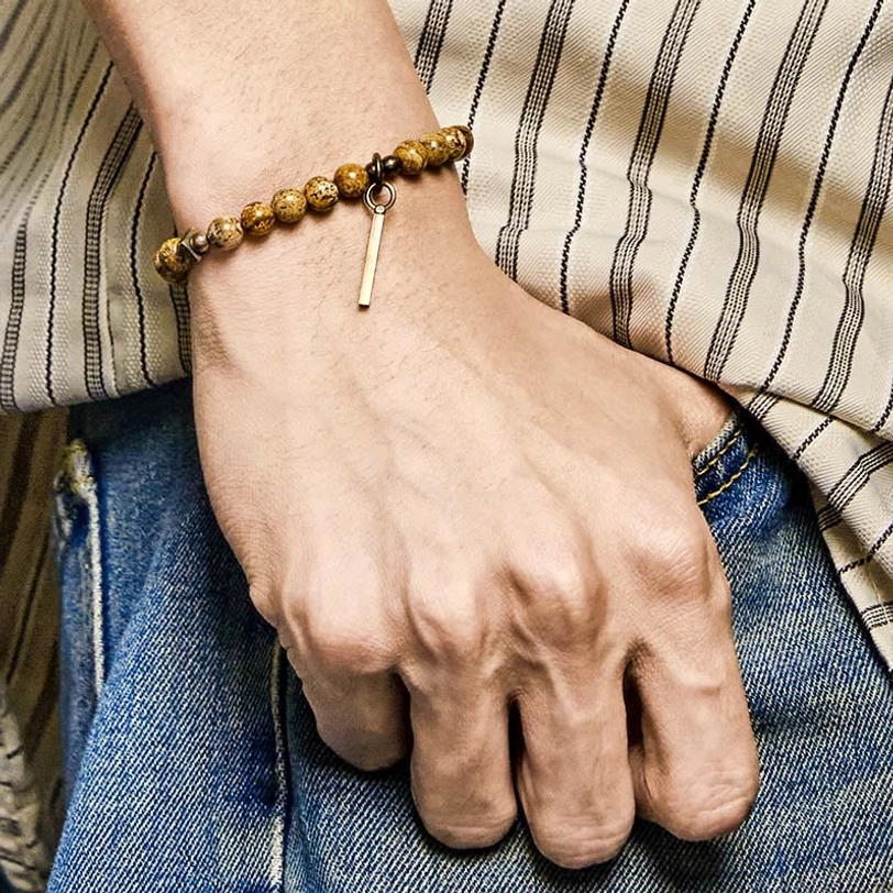 Wearing distressed copper luck bracelet on wrist, casual daily outfit styling with shirt and jeans