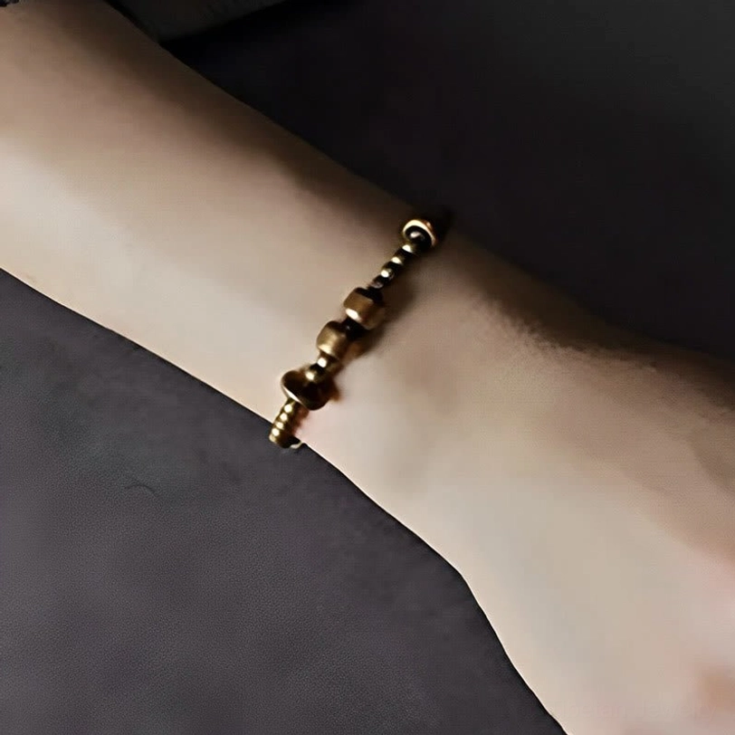 Vintage copper wealth bracelet worn on wrist showing slim stretch fit with antique bronze metal finish