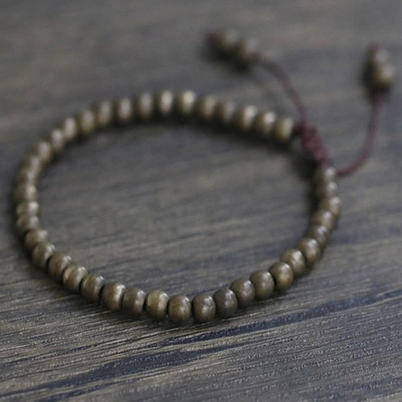 Product display of wealth-balancing copper beads bracelet with natural patina and Buddhist spiritual significance