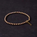 Copper brass healing bracelet with rectangular pendant displayed flat on dark background