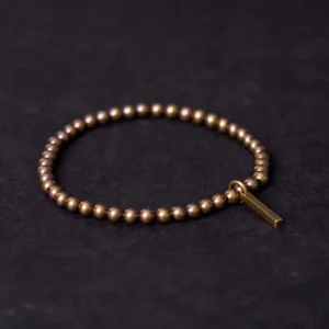 Copper brass healing bracelet with rectangular pendant displayed flat on dark background