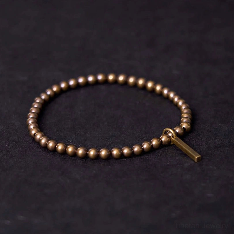 Copper brass healing bracelet with rectangular pendant displayed flat on dark background