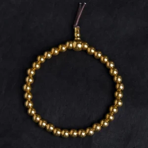 Complete copper bead mala bracelet with guru bead and tassel closure overhead view