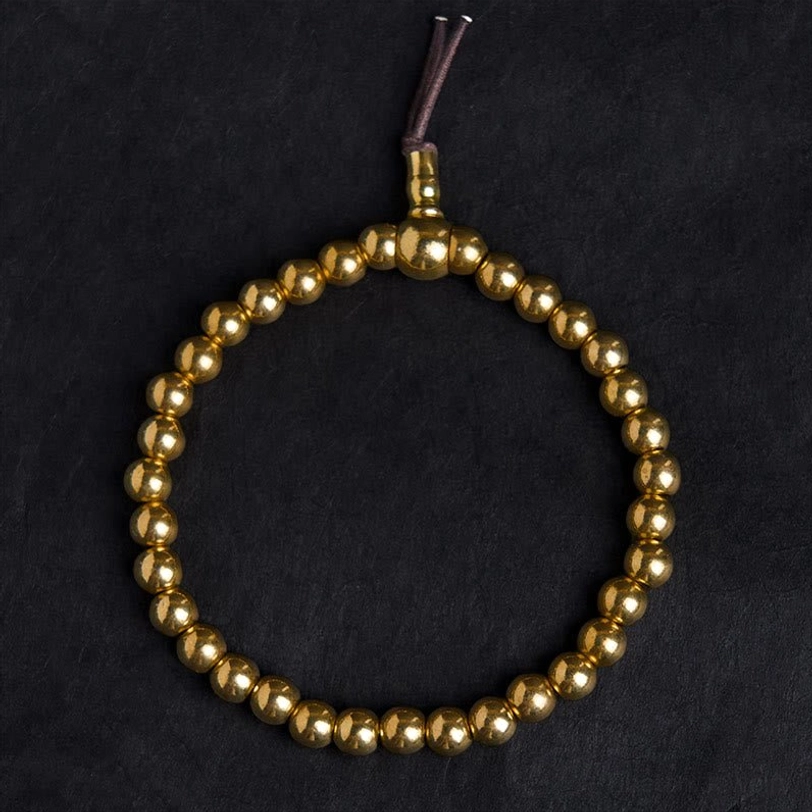 Complete copper bead mala bracelet with guru bead and tassel closure overhead view