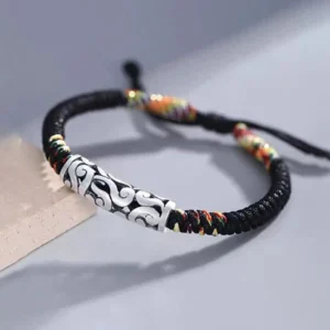 Handmade tibetan luck string bracelet overhead view showing adjustable pull knot closure and multicolored braided cord detail
