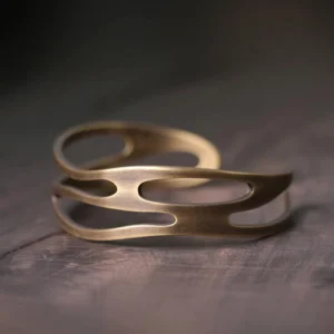 Front view of handcrafted copper wealth bracelet featuring asymmetrical hollow cutouts and matte bronze vintage finish