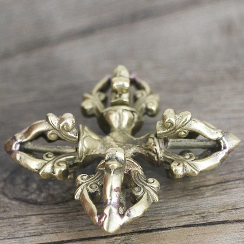 Copper double dorje from top-down view showcasing bright brass tone and sharp hollowed craft details on each symmetrical prong