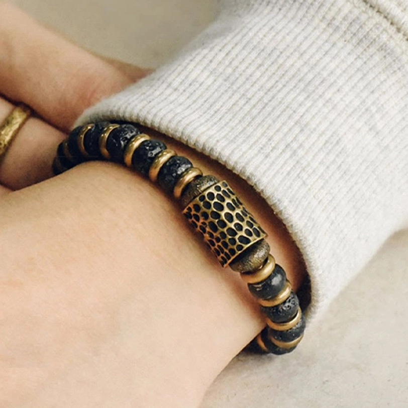 Grounding stone bracelet styled on wrist with knit sweater backdrop and gold ring showing natural fit