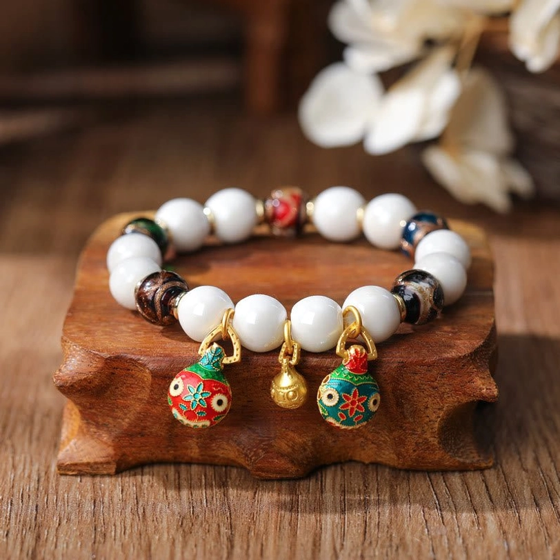 Copper Gold Pixiu charm bracelet with gradient colorful glass beads displayed overhead showing circular multicolor arrangement