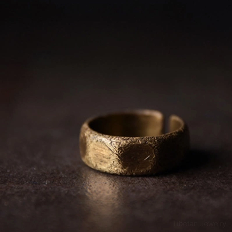 Low angle three-quarter view of frosted copper Tibetan ring - showing subtle scratch texture and bronze patina