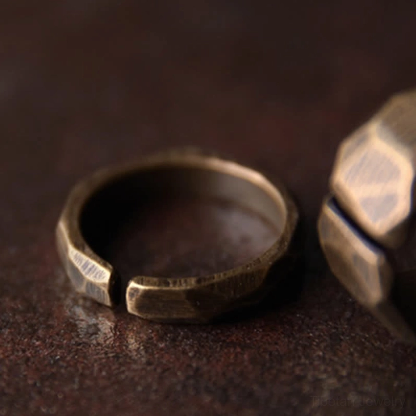 Two displayed copper rings side and front view comparison dark table