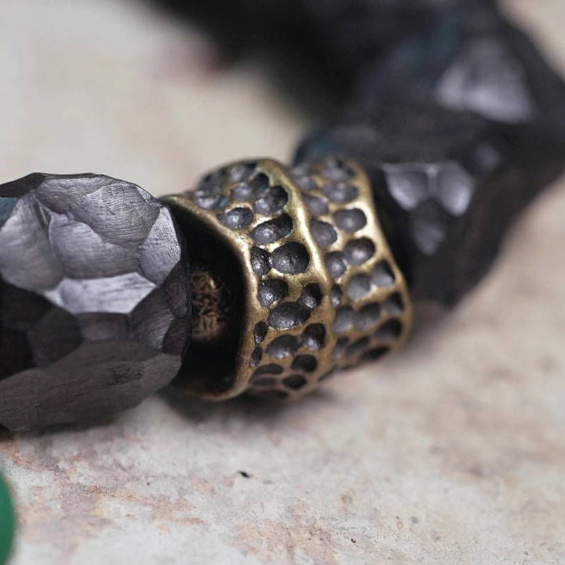 Copper spacer beads hollow carved detail between ebony wood beads macro shot