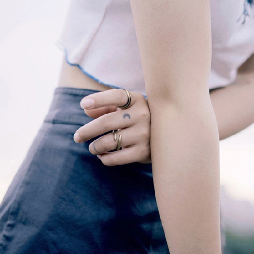 Open spiral copper ring worn casually paired with denim outfit and simple everyday jewelry aesthetic