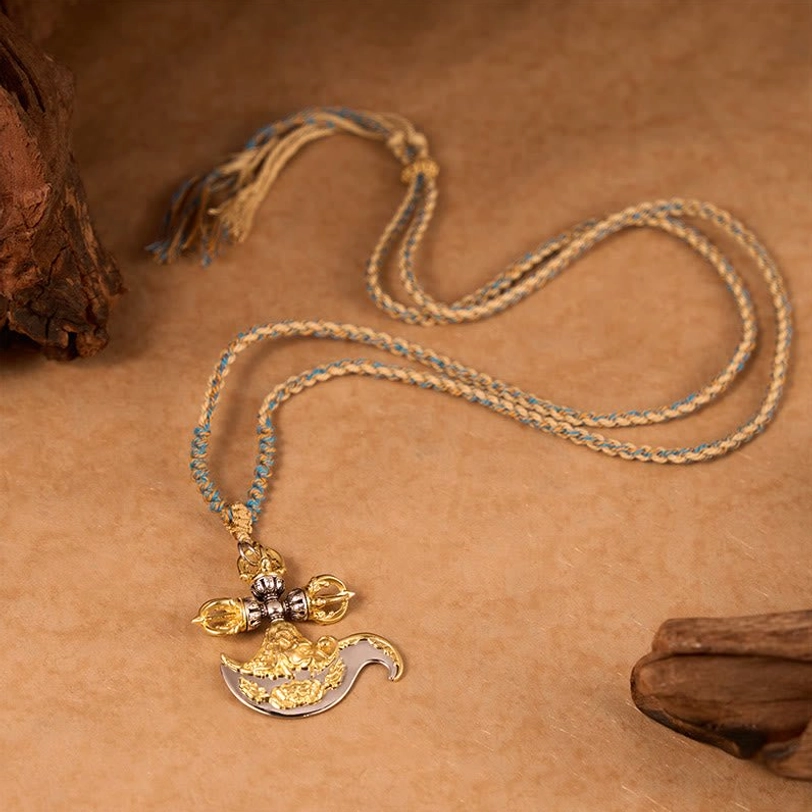 Flat lay overhead view of full length Tibetan vajra necklace with long braided tassel cord displaying complete length on brown craft paper and wooden surface