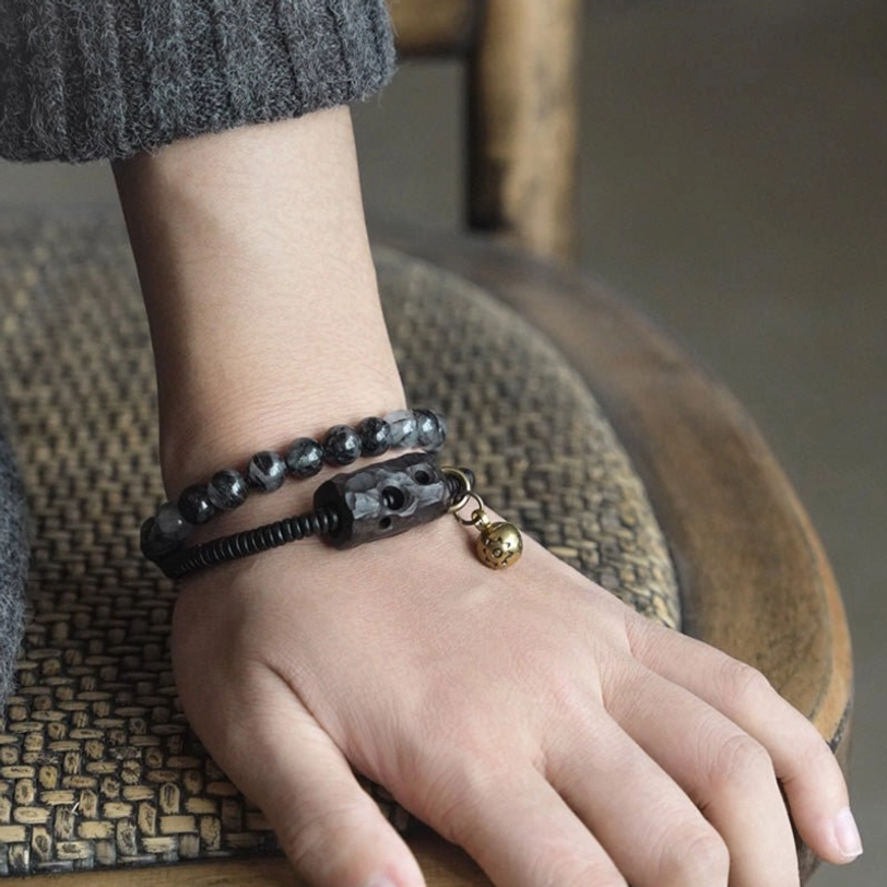 Side view of matching couple bracelets stacked on wrist with carved ebony accent and brass hardware