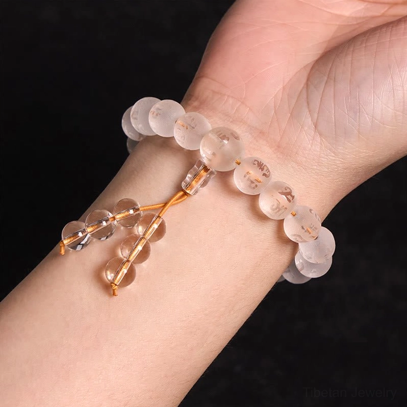 White crystal mala bracelet worn on left wrist showing neat bead arrangement and golden tassel