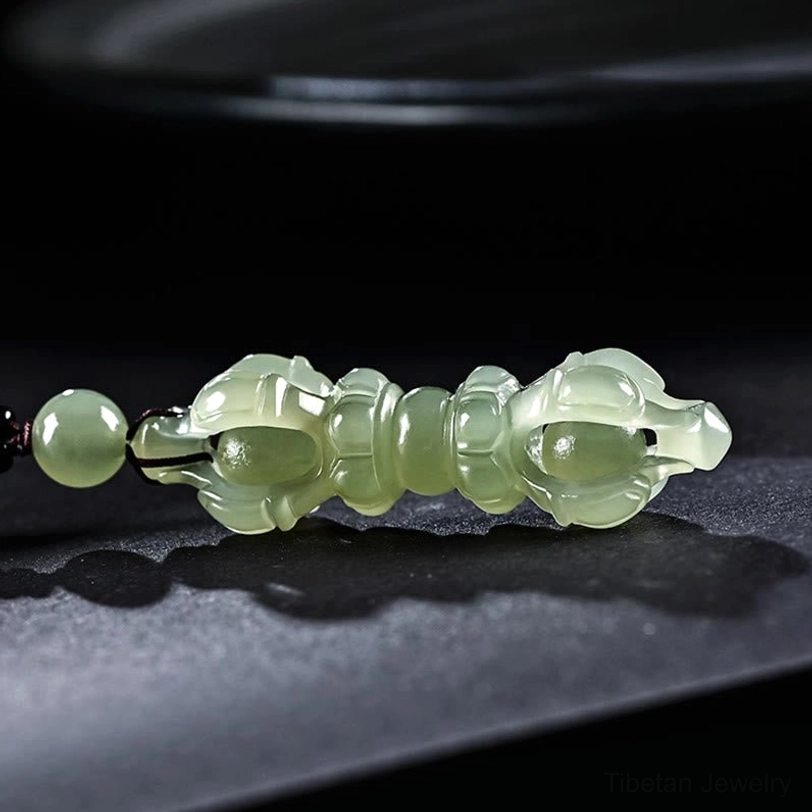 Cyan Hetian Jade Dorje Vajra pendant with hollow carved design and decorative top bead, side flat lay view