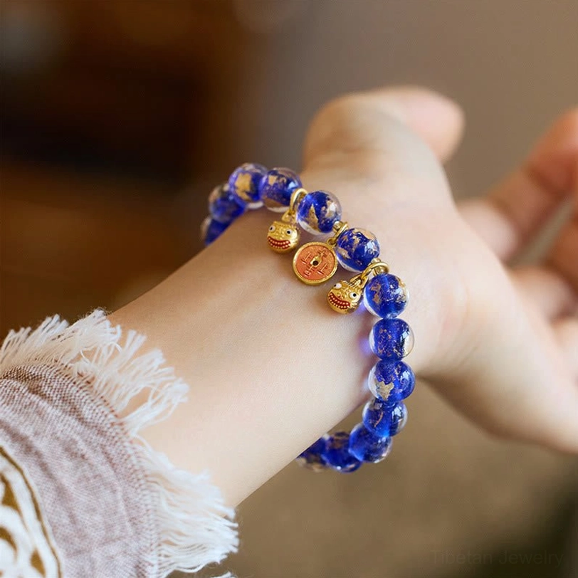 Dark blue liuli glass fortune bracelet with handcrafted gold Pi Xiu beast charm and prosperity symbol
