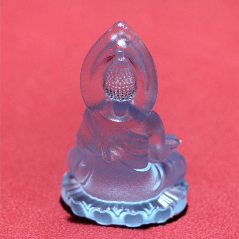 Dark blue Bhaisajyaguru Buddha pendant front view, meditative indigo crystal showing lotus base and Buddha deity carving with gem-inlaid setting