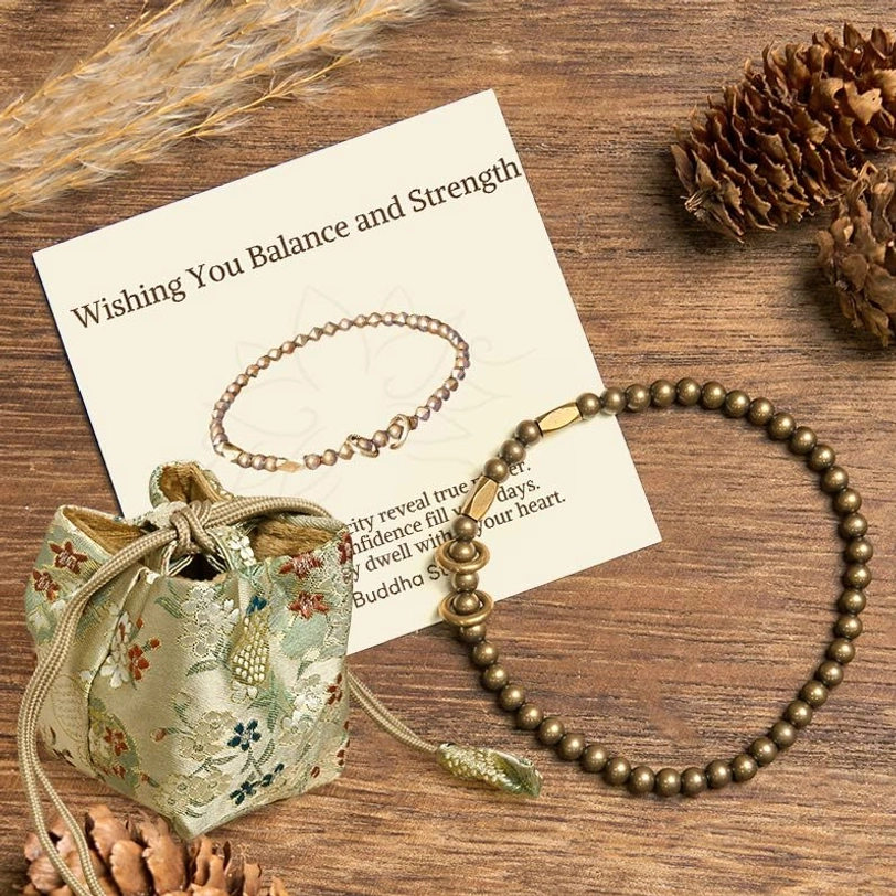 Deluxe embroidered gift bag with brass couple bracelet and blessing card on wooden desktop with natural elements