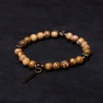 Distressed copper luck bracelet with natural stone beads, flat lay top view showing antique copper pendant charm