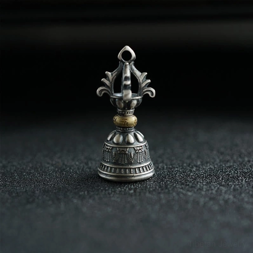 Ornate five-prong dorje bell with embossed religious motifs, frontal upright view of handcrafted silver pendant