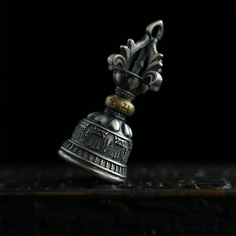 Dorje bell pendant side angle displaying hanging loop, engraved Om Mani Padme Hum patterns on silver body