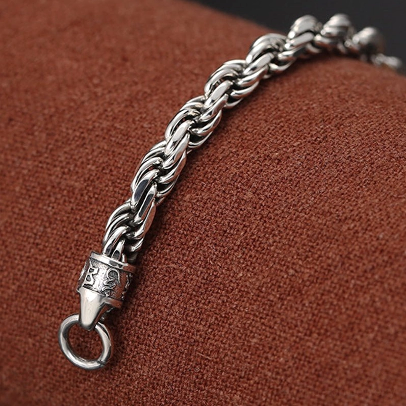 Detail shot of sterling silver bracelet end piece with decorative jump ring on Om Mani Padme Hum twisted design