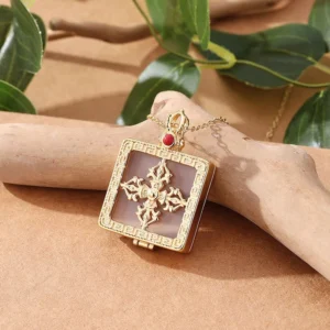 Hinged double dorje jade locket pendant with translucent white jade inlay and open gold case design