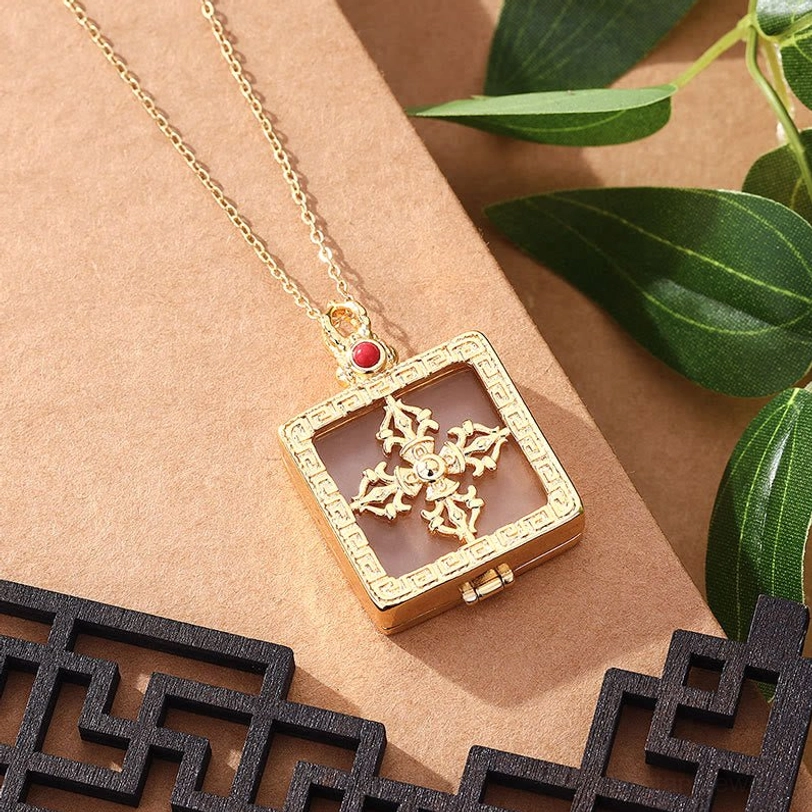 Double dorje white jade pendant necklace side view showing light brown jade insert with gold-toned hardware and red stone