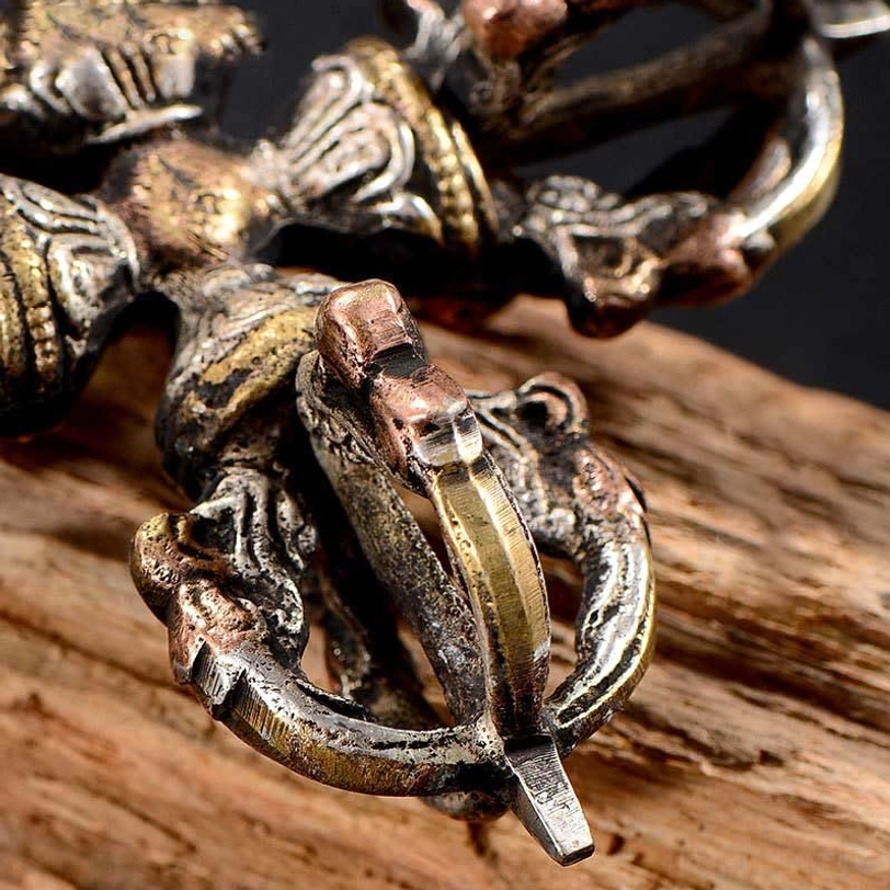 Close-up side view of handmade dorje vajra displaying visible metal joints and worn vintage patina detail