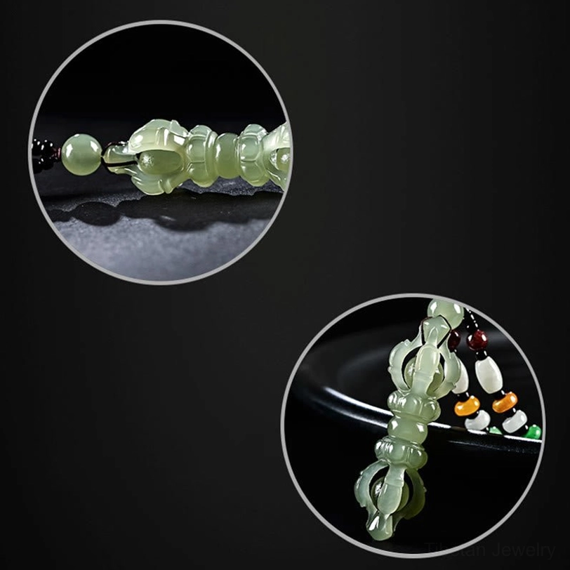 Close-up macro detail of Hetian Jade Dorje Vajra pendant showing hollow carving, translucent jade texture, and decorative beads