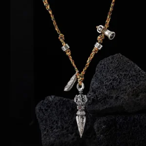 Close-up front view of Om Mani Padme Hum silver Dorje pendant necklace with engraved beads and feather charm on dark background