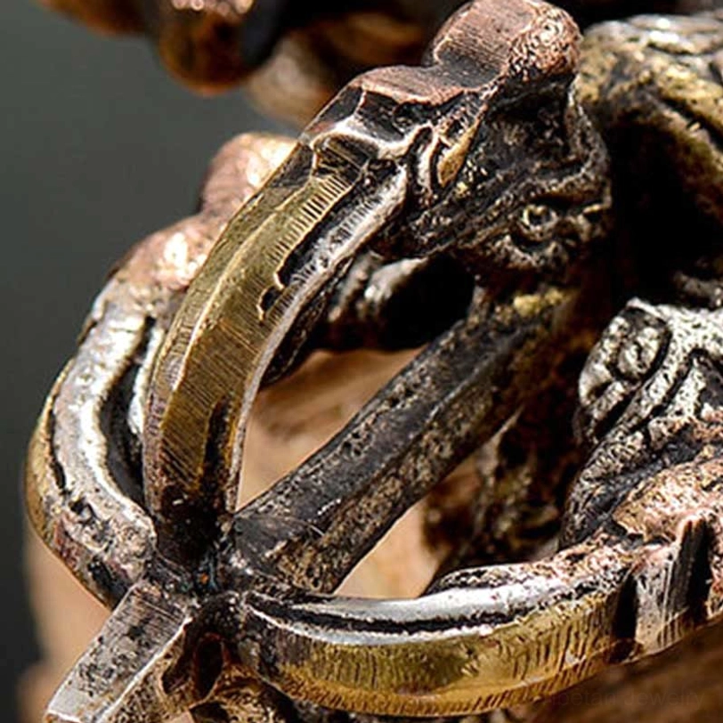 Extreme close-up of vajra prong details showing thick metal rings and aged mixed metal finish with carved reliefs