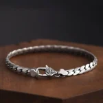 Double Dorje Vajra copper chain bracelet in antique finish, flat lay on wooden display stand