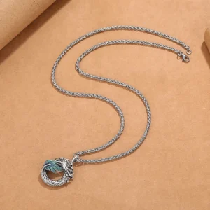Dragon necklace flat lay showing coiled silver chain and carved copper pendant - spiritual jewelry photography