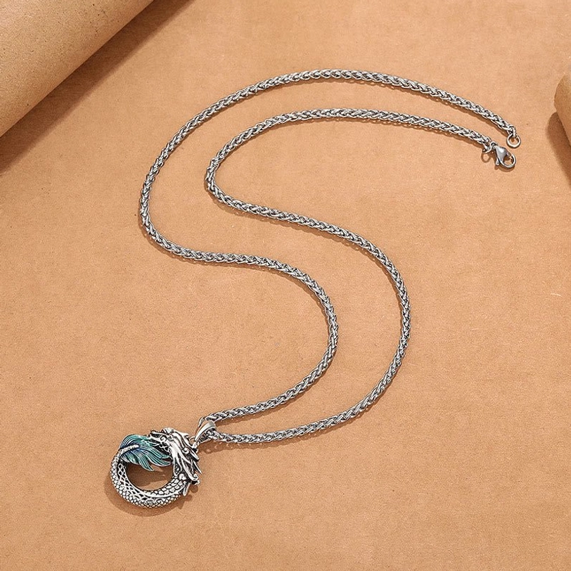 Dragon necklace flat lay showing coiled silver chain and carved copper pendant - spiritual jewelry photography
